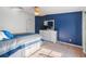 Cozy bedroom with blue accent wall, ceiling fan, and dresser set at 26438 Glenwood Dr, Wesley Chapel, FL 33544