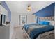 A spacious bedroom with blue accent wall, ceiling fan and large bed at 26438 Glenwood Dr, Wesley Chapel, FL 33544
