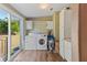 Practical laundry room with washer, dryer, storage cabinets, and a sliding glass door to the backyard at 26438 Glenwood Dr, Wesley Chapel, FL 33544