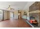Spacious living room featuring a stone fireplace, wood floors, and a ceiling fan at 26438 Glenwood Dr, Wesley Chapel, FL 33544