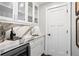 Chic bar area with glass-front cabinets, a marble countertop, and a wine refrigerator at 2903 Pass A Grille Way, St Pete Beach, FL 33706