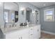 Bathroom with double sinks, white cabinets, granite countertops, and modern lighting fixtures at 2903 Pass A Grille Way, St Pete Beach, FL 33706