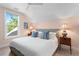 Comfortable bedroom with soft lighting, a king bed, and a view of the greenery outside the window at 2903 Pass A Grille Way, St Pete Beach, FL 33706