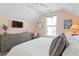 Light-filled bedroom with soft pastel colors, a TV, and a dresser providing ample storage space at 2903 Pass A Grille Way, St Pete Beach, FL 33706