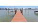 A wooden boat dock extends into the water, offering direct access for boating and water activities at 2903 Pass A Grille Way, St Pete Beach, FL 33706