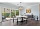 Elegant dining room with modern chandelier and backyard views through large sliding glass doors at 2903 Pass A Grille Way, St Pete Beach, FL 33706