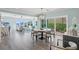Open-concept space with modern dining table, waterfront views, and elegant decor flowing into a sunlit living area at 2903 Pass A Grille Way, St Pete Beach, FL 33706