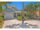 Charming home with a well-manicured lawn, lush landscaping, and a welcoming driveway at 2903 Pass A Grille Way, St Pete Beach, FL 33706