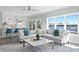Open living space featuring modern furniture, natural light, and a partial view of the kitchen and waterfront outside at 2903 Pass A Grille Way, St Pete Beach, FL 33706