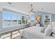 Waterfront main bedroom with many windows, a ceiling fan, and elegant coastal decor at 2903 Pass A Grille Way, St Pete Beach, FL 33706