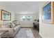 Bright home office features a gray sofa, desk, stylish decor, and a ceiling fan at 2903 Pass A Grille Way, St Pete Beach, FL 33706