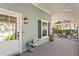Inviting front porch featuring a stylish door, decorative lighting, a small garden, and cozy outdoor seating at 2903 Pass A Grille Way, St Pete Beach, FL 33706