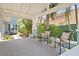 A cozy, covered porch with comfortable seating, lush greenery, and a view of the tranquil surroundings at 2903 Pass A Grille Way, St Pete Beach, FL 33706