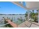 Stunning waterfront view from the balcony, showcasing the dock and boat lift on a sunny day at 2903 Pass A Grille Way, St Pete Beach, FL 33706