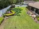 View of backyard that includes patio furniture set, flower beds, and mature landscaping at 3041 Colonial Ridge Dr, Brandon, FL 33511