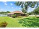 Enjoy a perfectly manicured backyard with green grass, lush landscaping, and a screened-in patio at 3041 Colonial Ridge Dr, Brandon, FL 33511