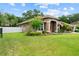 Lovely single-story home with a lush green lawn and inviting entrance, complete with mature trees and well-kept landscaping at 3041 Colonial Ridge Dr, Brandon, FL 33511