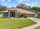 Lovely single-story home with a lush green lawn and inviting entrance, complete with mature trees and well-kept landscaping at 3041 Colonial Ridge Dr, Brandon, FL 33511