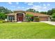 Well-maintained home with beautiful landscaping, featuring a mix of shrubs, flowers, and mulch beds at 3041 Colonial Ridge Dr, Brandon, FL 33511