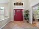 Spacious foyer features neutral tile, a bright red door and sidelights with decor and a sunny view to a Florida room at 3041 Colonial Ridge Dr, Brandon, FL 33511