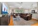 Cozy living room features hardwood floors, a leather sectional sofa, and large windows that bring in ample light at 3041 Colonial Ridge Dr, Brandon, FL 33511