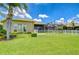 Lush backyard featuring manicured lawn, white picket fence and private lanai at 3123 Whitehead Ln, Land O Lakes, FL 34638