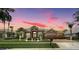 Charming home with manicured lawn, mature palms and brick paver driveway and entry at dusk in a gated community at 3123 Whitehead Ln, Land O Lakes, FL 34638