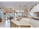 Bright, open kitchen with granite island, white cabinets, and views to the dining and living areas at 3123 Whitehead Ln, Land O Lakes, FL 34638