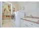 A well-equipped laundry room with a washer, dryer, sink, and storage shelves at 3123 Whitehead Ln, Land O Lakes, FL 34638