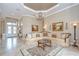 A sun-filled living room with a chandelier, paintings, and a decorative area rug at 3123 Whitehead Ln, Land O Lakes, FL 34638