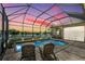 Inviting screened pool area with waterfront views at dusk and patio seating at 3123 Whitehead Ln, Land O Lakes, FL 34638