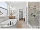 Elegant bathroom featuring a soaking tub, glass enclosed shower and sleek marble countertops at 33487 Azalea Ridge Dr, Wesley Chapel, FL 33545
