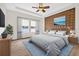 Comfortable bedroom with stylish paneled wall, ceiling fan and natural light from the large windows at 33487 Azalea Ridge Dr, Wesley Chapel, FL 33545