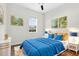 Cozy bedroom featuring large bed with blue cover, hardwood floors, and ceiling fan at 33487 Azalea Ridge Dr, Wesley Chapel, FL 33545