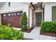Charming entrance with stone accents, a green door, and a neatly landscaped yard at 33487 Azalea Ridge Dr, Wesley Chapel, FL 33545
