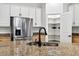 Kitchen highlights granite countertop, stainless steel refrigerator, pantry with storage shelves, and stainless steel sink at 33487 Azalea Ridge Dr, Wesley Chapel, FL 33545