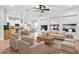 Bright living room open to the kitchen, with hardwood floors, white seating, and large bright windows at 33487 Azalea Ridge Dr, Wesley Chapel, FL 33545