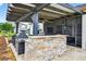 An outdoor bar area with stone facade, countertops, a built-in grill, and views of the backyard at 33487 Azalea Ridge Dr, Wesley Chapel, FL 33545