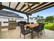 Charming outdoor dining area with a ceiling fan, grill, and well-maintained landscaping at 33487 Azalea Ridge Dr, Wesley Chapel, FL 33545