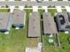 Aerial view of homes with well-kept lawns and a backyard with a pool and patio at 35552 Shade Fern Ln, Zephyrhills, FL 33541