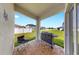 A covered back porch with tile flooring, overlooking the expansive fenced yard at 35552 Shade Fern Ln, Zephyrhills, FL 33541