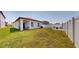 A large backyard with a covered patio, lush lawn, and a fenced perimeter at 35552 Shade Fern Ln, Zephyrhills, FL 33541