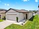 Charming single-story home featuring a well-manicured lawn and a two-car garage at 35552 Shade Fern Ln, Zephyrhills, FL 33541