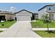Charming one-story home with a well-manicured lawn, two-car garage, and inviting entryway at 35552 Shade Fern Ln, Zephyrhills, FL 33541