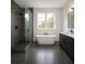 Modern bathroom with standalone tub, glass shower, and sleek dark vanity at 3800 Shore Acres Ne Blvd, St Petersburg, FL 33703