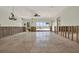 Spacious living room featuring tile flooring, ceiling fan, and bright sliding glass doors to the water at 3800 Shore Acres Ne Blvd, St Petersburg, FL 33703