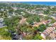 Aerial view showcasing a property with a red outline, surrounded by trees and neighborhood with water in the distance at 4711 W Vasconia St, Tampa, FL 33629