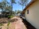 Spacious backyard with brick pathway surrounded by greenery and large trees providing ample shade at 4711 W Vasconia St, Tampa, FL 33629