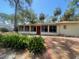 Back exterior of home featuring a sunroom with multiple windows and access to the yard at 4711 W Vasconia St, Tampa, FL 33629