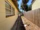 Exterior side view showing a narrow walkway and wooden fence along the home at 4711 W Vasconia St, Tampa, FL 33629